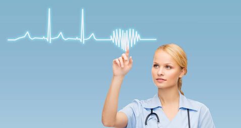 female doctor or nurse pointing to cardiogram