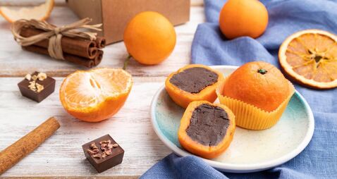 Truffle chocolate tangerine candies on a white wooden background. Side view.