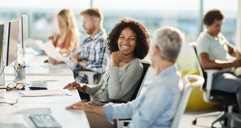 Happy programmers talking while working in the office.