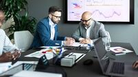 Business professionals analyzing data in a meeting with charts and reports displayed