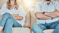 Unknown couple fighting and giving each other the silent treatment. Caucasian man and woman sitting on the sofa with their arms