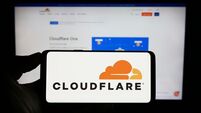 Stuttgart, Germany, 06-17-2023: Person holding cellphone with logo of US ICT company Cloudflare Inc. on screen in front of busin