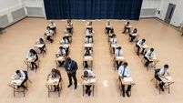 One male teacher checking on rows of teenage students taking a school exam shot from a high angle perspective, Newcastle upon Ty