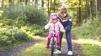 Cute little preschool girl in safety helmet riding bicycle. School kid boy, brother teaching happy healthy sister child cycling