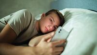 Teenager Using Cell Phone in Bed