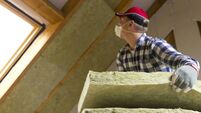 Man installing thermal roof insulation layer - using mineral wool panels. Attic renovation and insulation concept