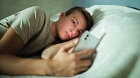 Teenager Using Cell Phone in Bed