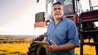 Portrait of an agronomist with a tablet in front of the agricultural machine