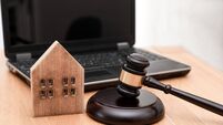 Wooden House Model and Judge Gavel on Desk with Laptop in the Background ,Real Estate Law or property law concept