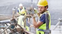 Construction worker carrying metal bar at construction site