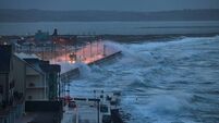 Giant waves and violent storm jumping over the pier in the seaside town of Tramore, Waterford, Ireland. horizontal format