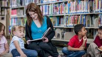 Teacher Reading a Book to Students