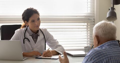 Female doctor therapist listening to patient complaints, filling form