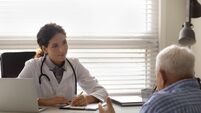 Female doctor therapist listening to patient complaints, filling form